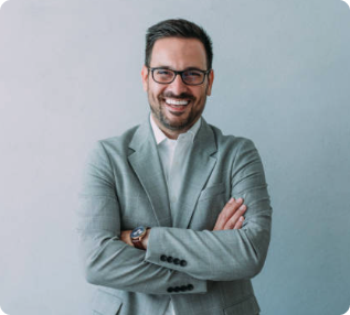 Professional insurance adjuster in gray suit and glasses with arms crossed, smiling confidently